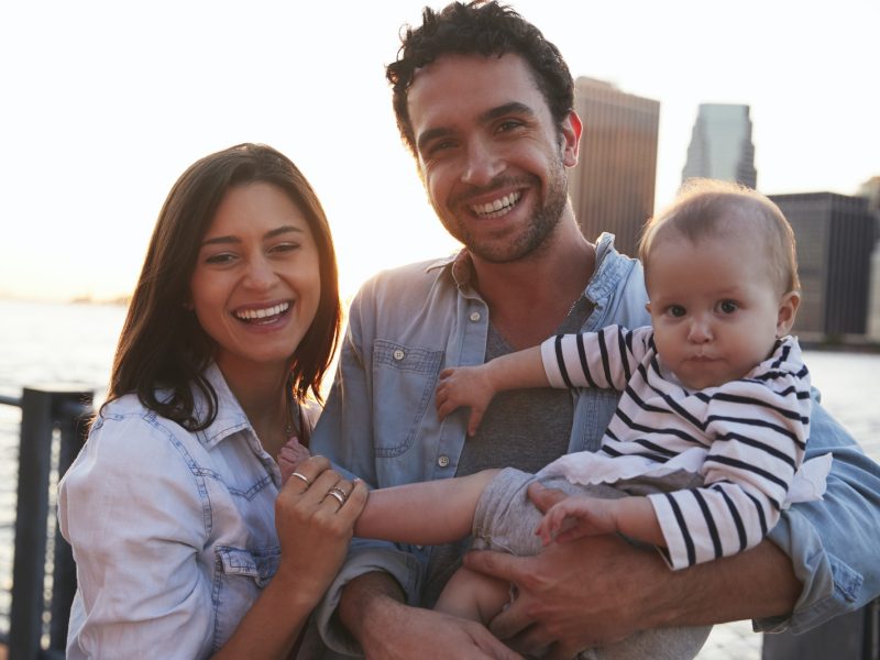 Young family with daughter standing on quayside, close up